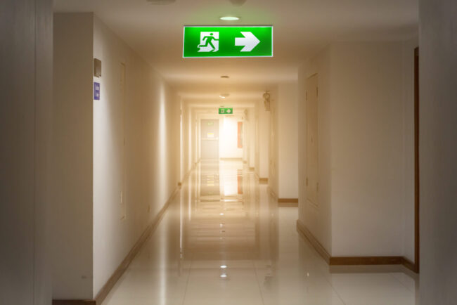 Green,Emergency,Exit,Sign,In,Hotel,Showing,The,Way,To